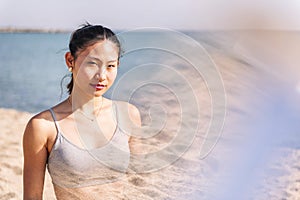 young contemplative asian female at beach