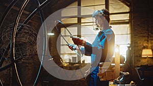 Young Contemporary Female Artist in Blue Jumpsuit and Safety Mask is Fitting a Metal Ring to a Tub