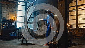 Young Contemporary Female Artist in Blue Jumpsuit and Safety Mask is Fitting a Metal Ring to a Tub