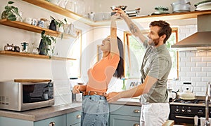 Young content interracial couple dancing in the kitchen at home. Playful caucasian boyfriend and mixed race girlfriend