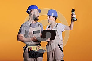 Young contractors partners in studio holding laptop