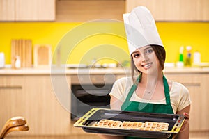 The young cook cooking cakes in the kitchen