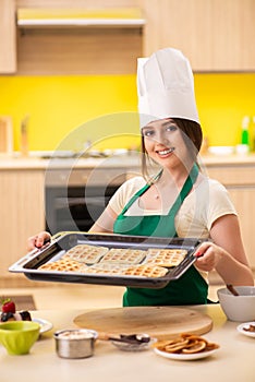 The young cook cooking cakes in the kitchen