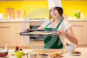 The young cook cooking cakes in the kitchen