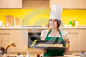 The young cook cooking cakes in the kitchen