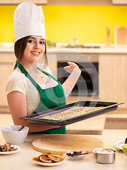 Young cook cooking cakes in the kitchen