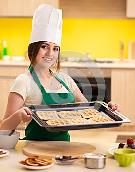 Young cook cooking cakes in the kitchen