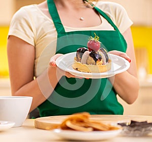 Young cook cooking cakes in the kitchen