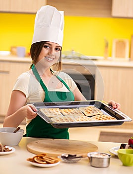 Young cook cooking cakes in the kitchen