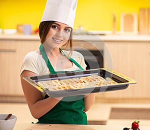 Young cook cooking cakes in the kitchen