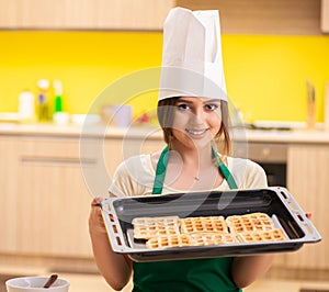 Young cook cooking cakes in the kitchen