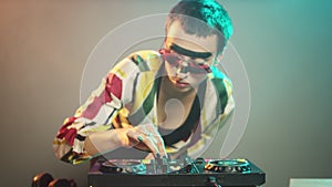 Young cool artist working as dj with turntables