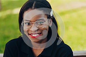 Young cool black skin girl with glasses walking in the street