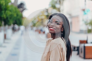 Young cool black skin girl with glasses walking in the street