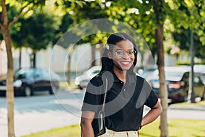 Young cool black skin girl with glasses walking in the street