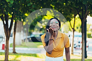 Young cool black skin girl with glasses walking in the street