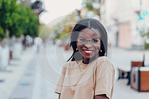 Young cool black skin girl with glasses walking in the street