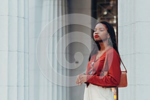 Young cool black skin girl with glasses walking in the street