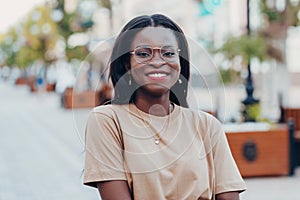 Young cool black skin girl with glasses walking in the street