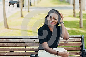 Young cool black skin girl with glasses walking in the street