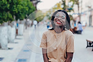 Young cool black skin girl with glasses walking in the street