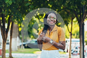 Young cool black skin girl with glasses walking in the street