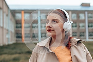 Young cool student woman listening to music with headphones