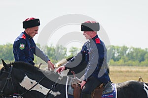 Young Cossacks in traditional costumes on horseback