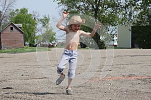 Young country boy jumps and plays on farm