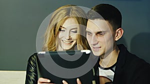 Young couple 20-25 years uses the tablet in cafe