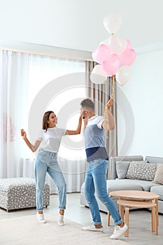 Young couple with air balloons at home.  of Saint Valentine`s Day