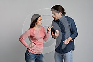 Young couple arguing. Angry millennial girl blaming her boyfriend