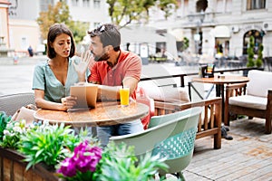 Young couple arguing in cafe. People, cheating, conflict, relationship problems concept.