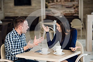 Young couple arguing in a cafe. She`s had enough, boyfriend is apologizing. Relationship problems.