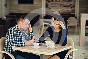 Young couple arguing in a cafe. She`s had enough, boyfriend is apologizing. Relationship problems.