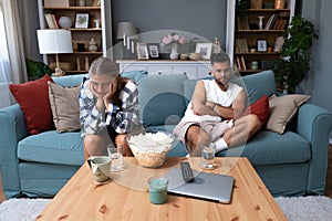 Young couple are arguing on the couch in their home and having difficulty and problems in a relationship and marriage sitting back