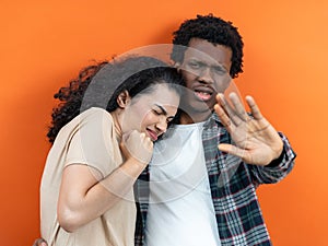 Young Couple Arguing, Man Gesturing Stop, Orange Background