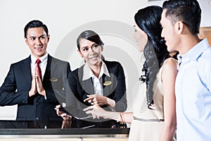 Young couple arriving at hotel reception area