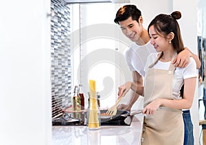 Young couple asian together man and woman cooking food for dinner salad