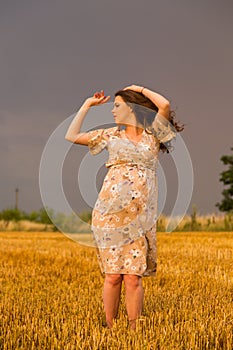 Young couple awaiting baby embrace the field