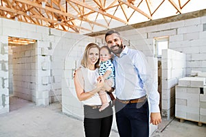 Young couple with a baby at the construction site.