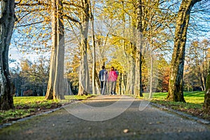 Young couple with a baby walking through an autumn park