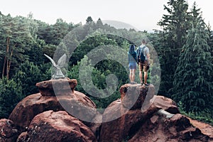 Young Couple Of Backpackers Standing On Top Of Mountain And Enjoying View Of Nature In Summer