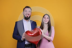 Young couple with a balloon heart.