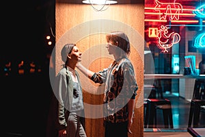 Young couple at the bar, street of the night city