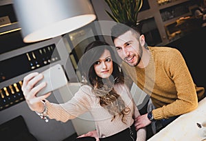 Young couple at the bar taking a selfie