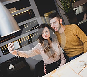 Young couple at the bar taking a selfie