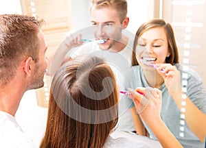 Young couple in the bathroom brushing teeth