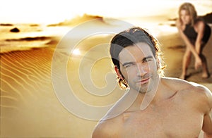 Young couple on the beach with focus on man