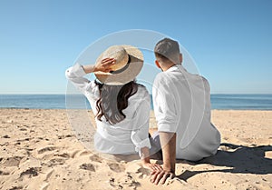 Young couple on beach near sea. Honeymoon trip